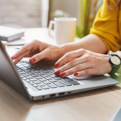 Hände auf einem Laptop in einem modernen Büro, symbolisiert effiziente Nutzung von Software in der Zeitarbeitsbranche.