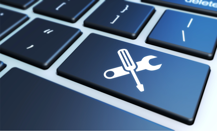 Digitale Werkzeuge für effiziente Zeitarbeitslösungen Symbol eines Schraubenziehers und Schraubenschlüssels auf einer Computertastatur, symbolisiert digitale Werkzeuge für Zeitarbeit.