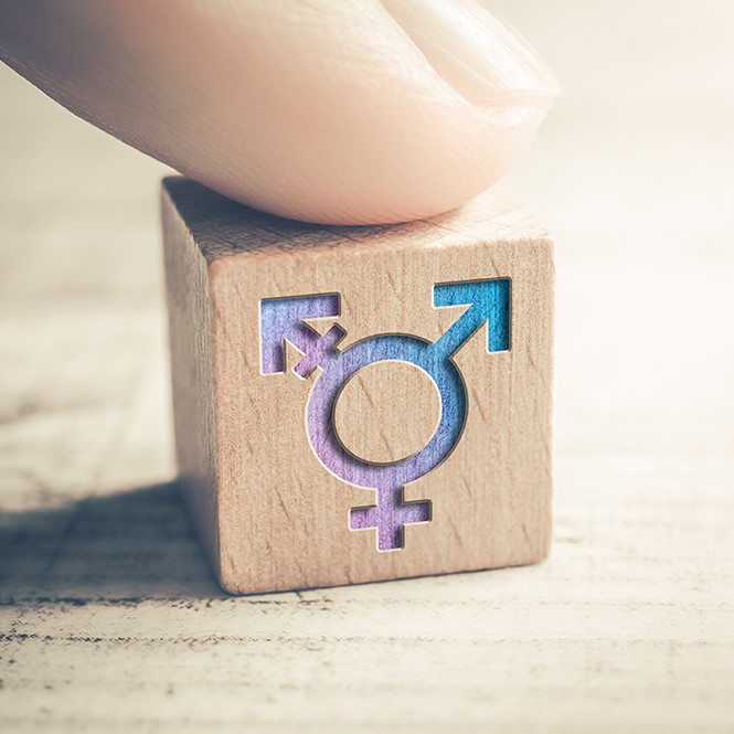 Transgender LGBT oder Intersex Symbol das von einem Finger auf einem Block auf einem Tisch platziert wird