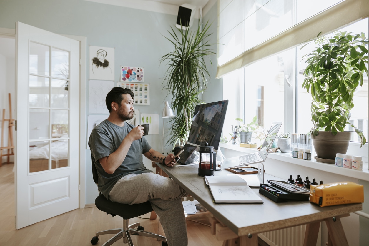 Home Office Mann vor PC Ein Mann sitzt im Home Office und schaut nachdenkend aus dem Fenster