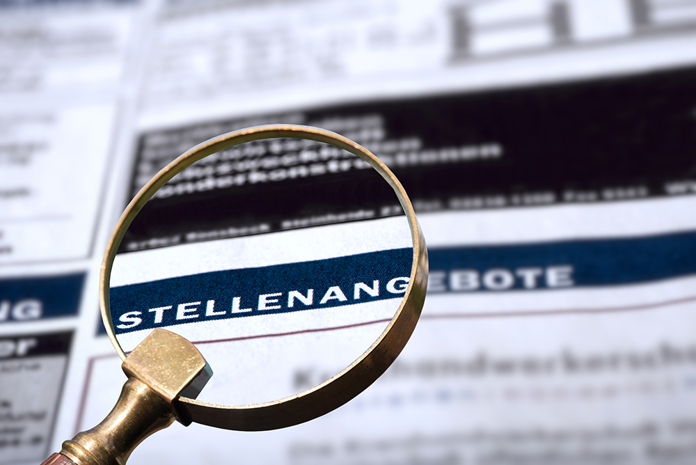 Zeitung mit Stellenangebote Eine Zeitung bei der eine Lupe über dem Thema Stellenangebote gelegt wurde