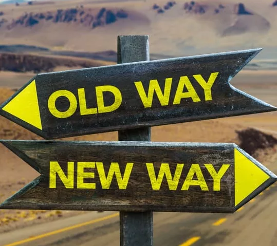 Wegweiser in einer Wüstenlandschaft. Ein Pfeil zeigt nach links mit der Aufschrift 'Old Way', ein anderer nach rechts mit der Aufschrift 'New Way'